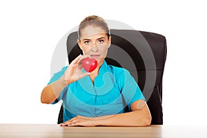 Young female doctor holding toy heart