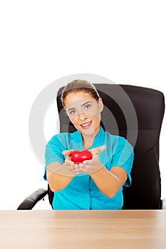 Young female doctor holding toy heart