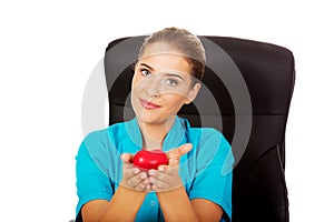 Young female doctor holding toy heart