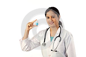 Young female doctor holding up a pill