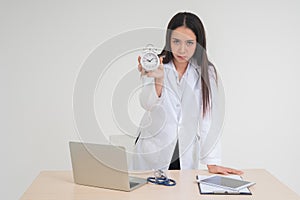 Young female doctor holding a white clock. Concept of health care Easier than treating illnesses