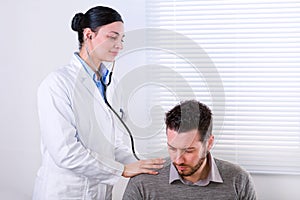 Young female doctor listening to a heartbeat