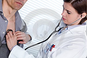 Young female doctor listening to a heartbeat