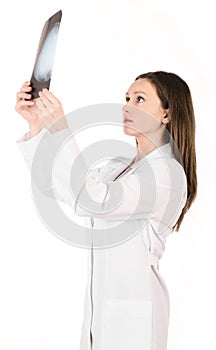 Young female doctor looking at the x-ray picture of head isolate