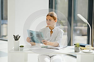 Young female doctor looking at the x-ray picture of lungs in hospital.