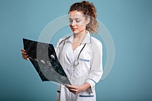 Young female doctor looking at roentgenogram photo
