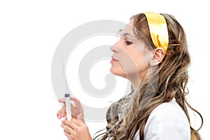 Young female doctor looking at syringe needle