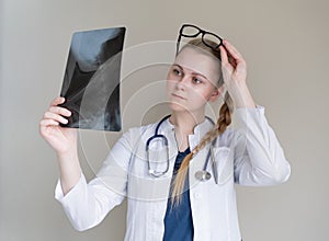 Young female doctor looking at x-ray of cervical spine, medicine concept