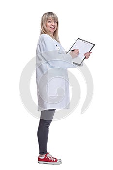 young female doctor making notes in a clipboard .