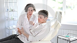 Young female doctor and male patient talking before signing of medical contract