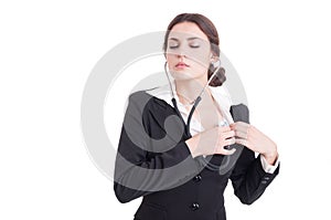 Young female doctor or medic listening her heart with stethoscop