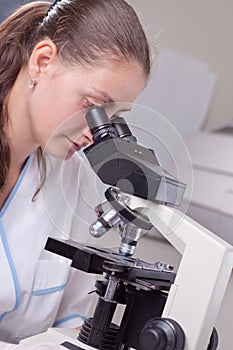 Young female doctor with microscope