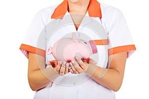 Young female doctor or nurse holding a piggybank