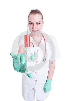 Young female doctor or nurse showing syringe in close-up