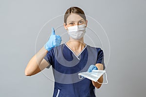 Young female doctor offering a face mask