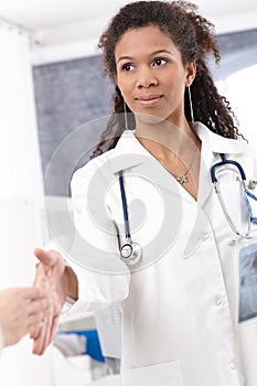 Young female doctor shaking hands