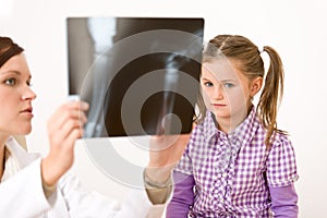 Young female doctor show x-ray to child