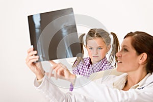 Young female doctor show x-ray to child