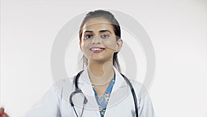 Young female doctor showing an apple with an OK gesture - white background