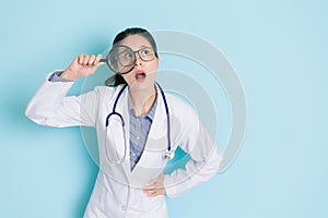 Young female doctor standing in blue background