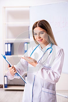 The young female doctor standing in front of the white board