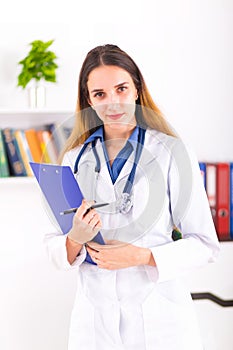 Young female doctor in uniform in doctor`s ofice writting a document