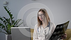 Young female doctor in white uniform talking to camera