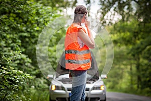 Young female driver calling the roadside service