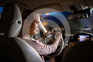 Young female driver driving her car at night