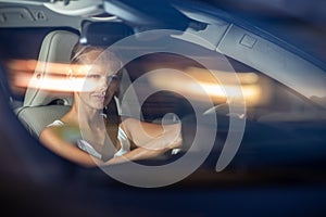 Young female driver driving her car at night