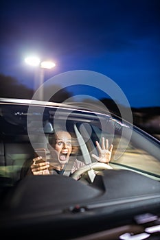 Young female driver playing with her cellphone