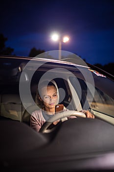 Young female driver playing with her cellphone