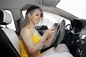 Young female driver using touch screen smartphone and gps navigation in a car.