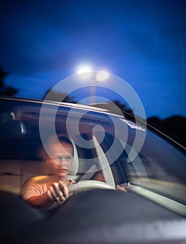 Young female driver at the wheel of her car, super tired