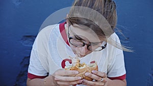 Young female eats a big burger