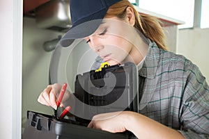 young female electrician searching tool in toolbox