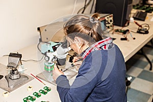 Young female electronic technician at work.