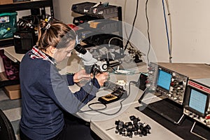 Young female electronic technician at work.
