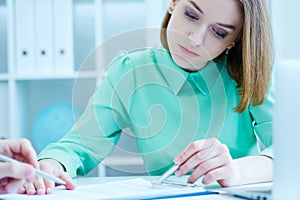 Young female employee of the staffing agency helps fill out the form to the male job seeker. Business, office, law and photo