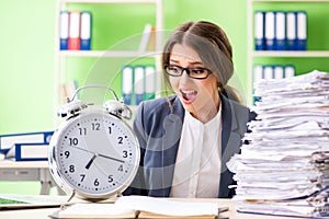 Young female employee very busy with ongoing paperwork in time m