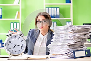 Young female employee very busy with ongoing paperwork in time m