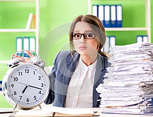 Young female employee very busy with ongoing paperwork in time m