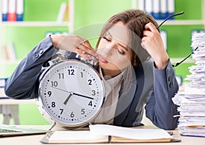 Young female employee very busy with ongoing paperwork in time m