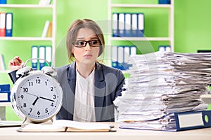 Young female employee very busy with ongoing paperwork in time m photo