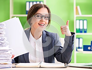 Young female employee very busy with ongoing paperwork