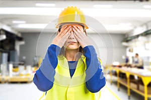 Young female engineer covering her eyes