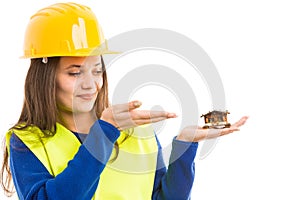 Young female engineer holding small house