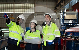 Young female engineer learning to run machinery at a factory with veteran engineers