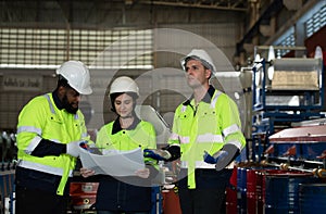 Young female engineer learning to run machinery at a factory with veteran engineers