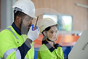 Young female engineer learning to run machinery at a factory with veteran engineers